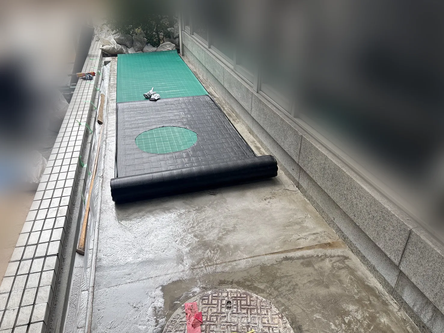 地下ピット上部の施工面に通気シートを敷設する様子