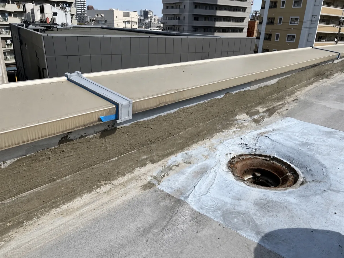 既存立上り防水層の浮き・めくれ部分を下地調整する様子