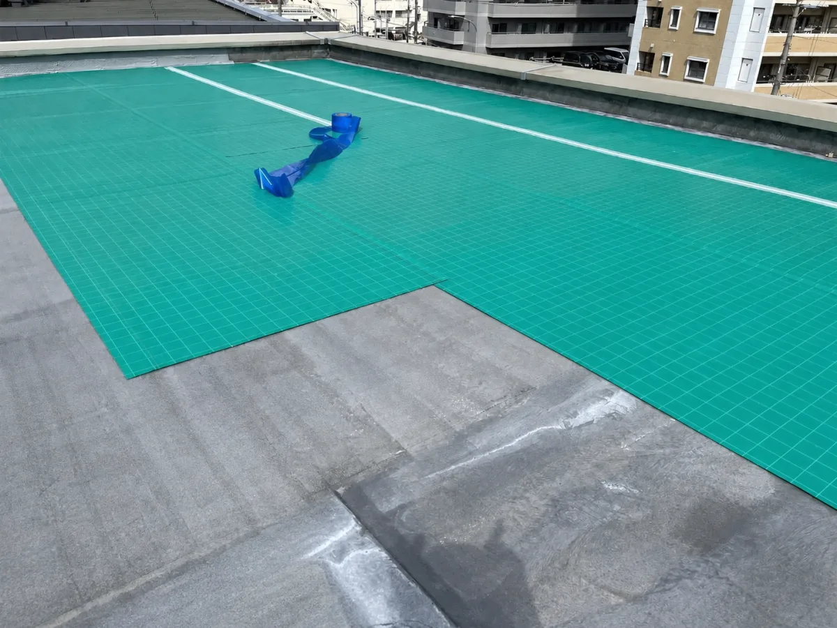 屋上に通気緩衝シートを張る様子