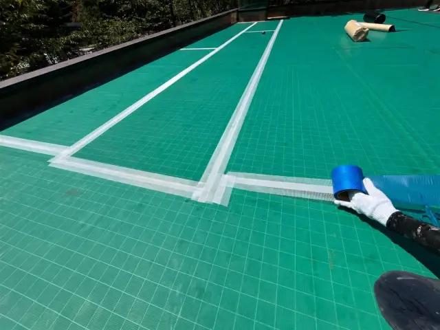シート端部にジョイントテープを貼る様子
